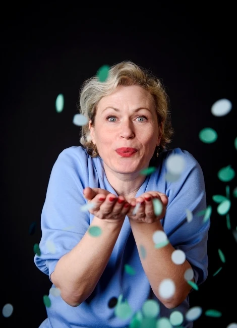 Personal Brand Fotografie in München - lebendiges Studio-Porträt einer Unternehmerin mit Konfetti vor dunklem Hintergrund