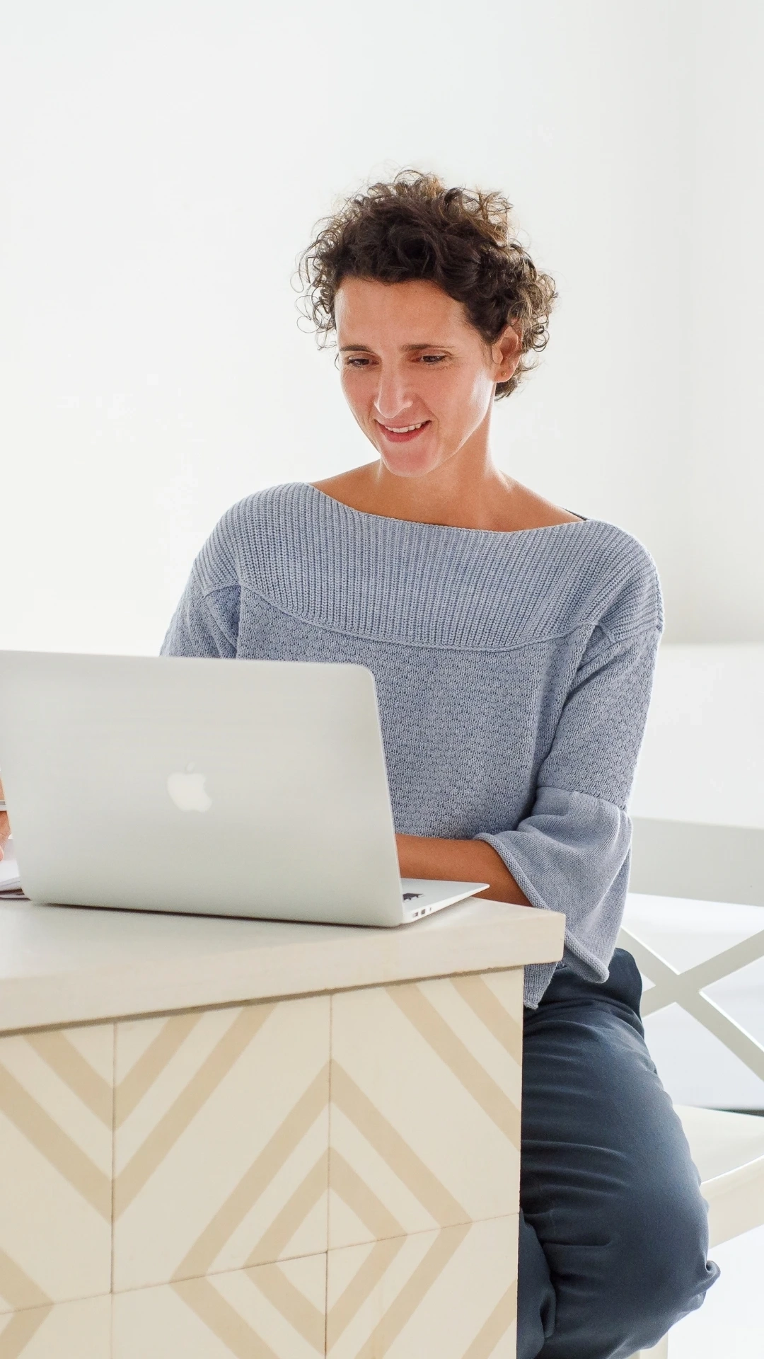 Personal Brand Fotografie in München - Unternehmerin arbeitet konzentriert am Laptop in heller Arbeitsumgebung